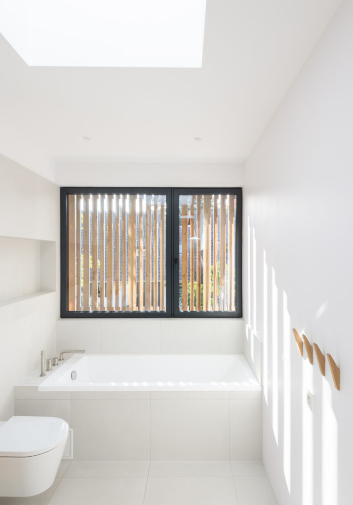 Kleines, weißes Badezimmer mit Holzelementen