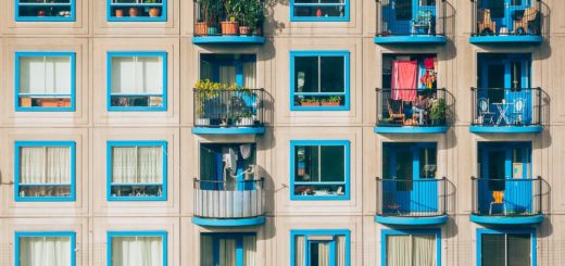 Haus mit blau gestrichenen Fensterläden und üppiger Balkonbepflanzung