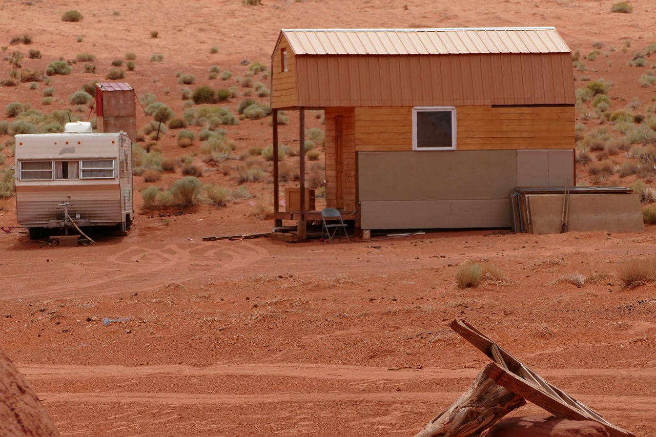 Kleines Modulhaus in der Wüste neben einem Wohnmobil