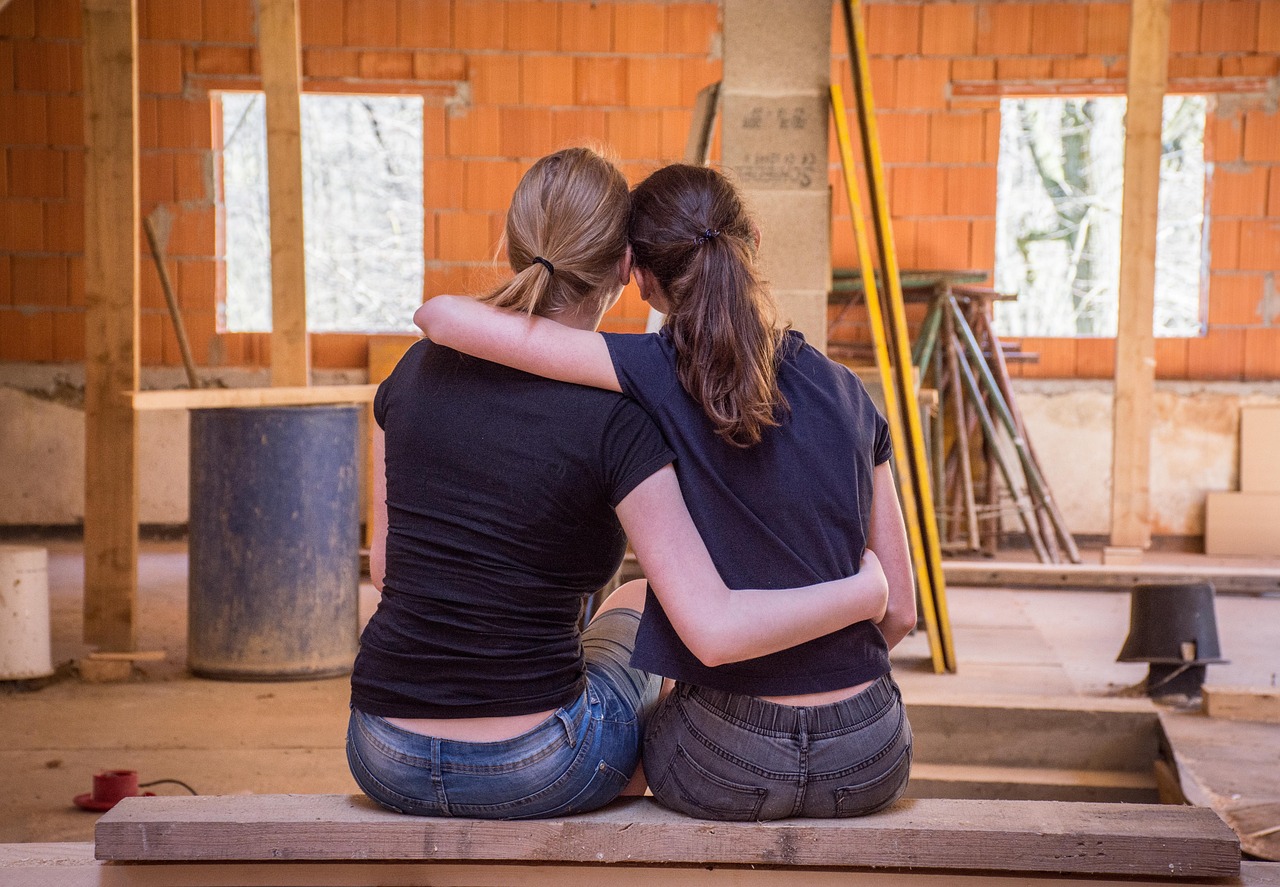 Zwei sich umarmende Frauen während Renovierungsarbeiten