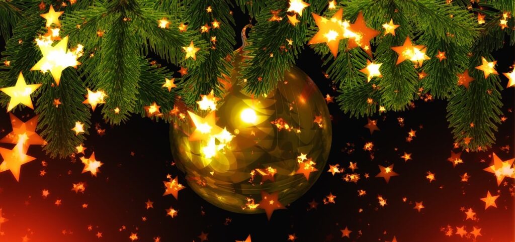 Bildausschnitt eines Weihnachtsbaums mit goldener Baumkugel und Sterneffekten