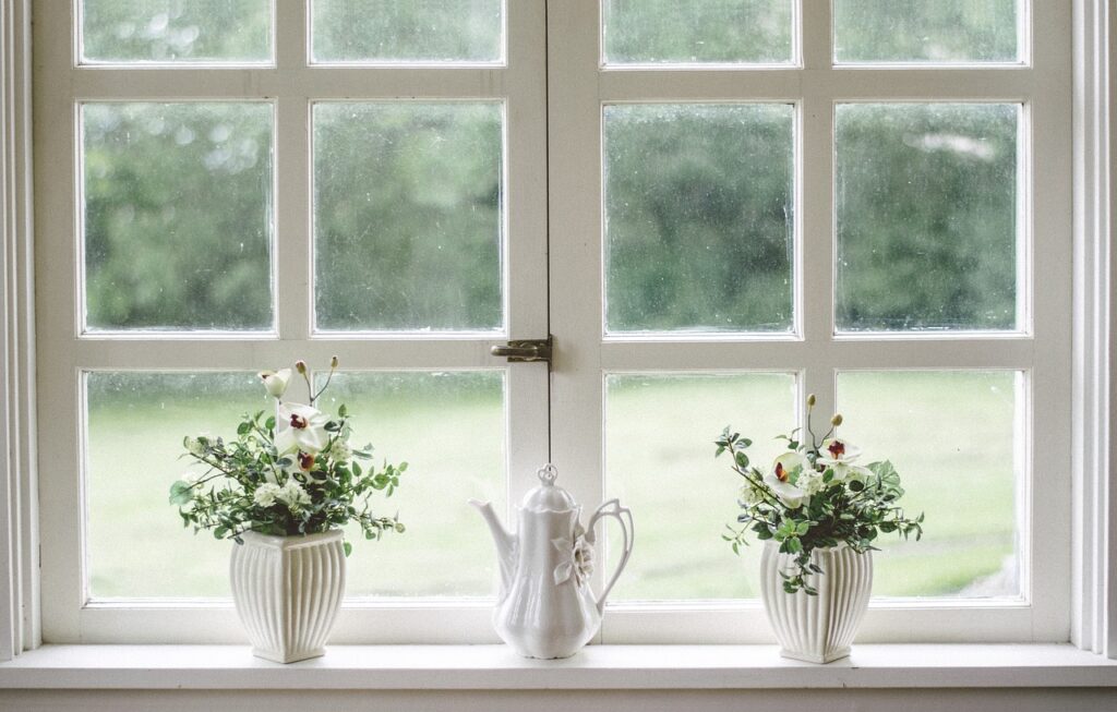Weiße, rustikale Holzfenster mit Pflanzen