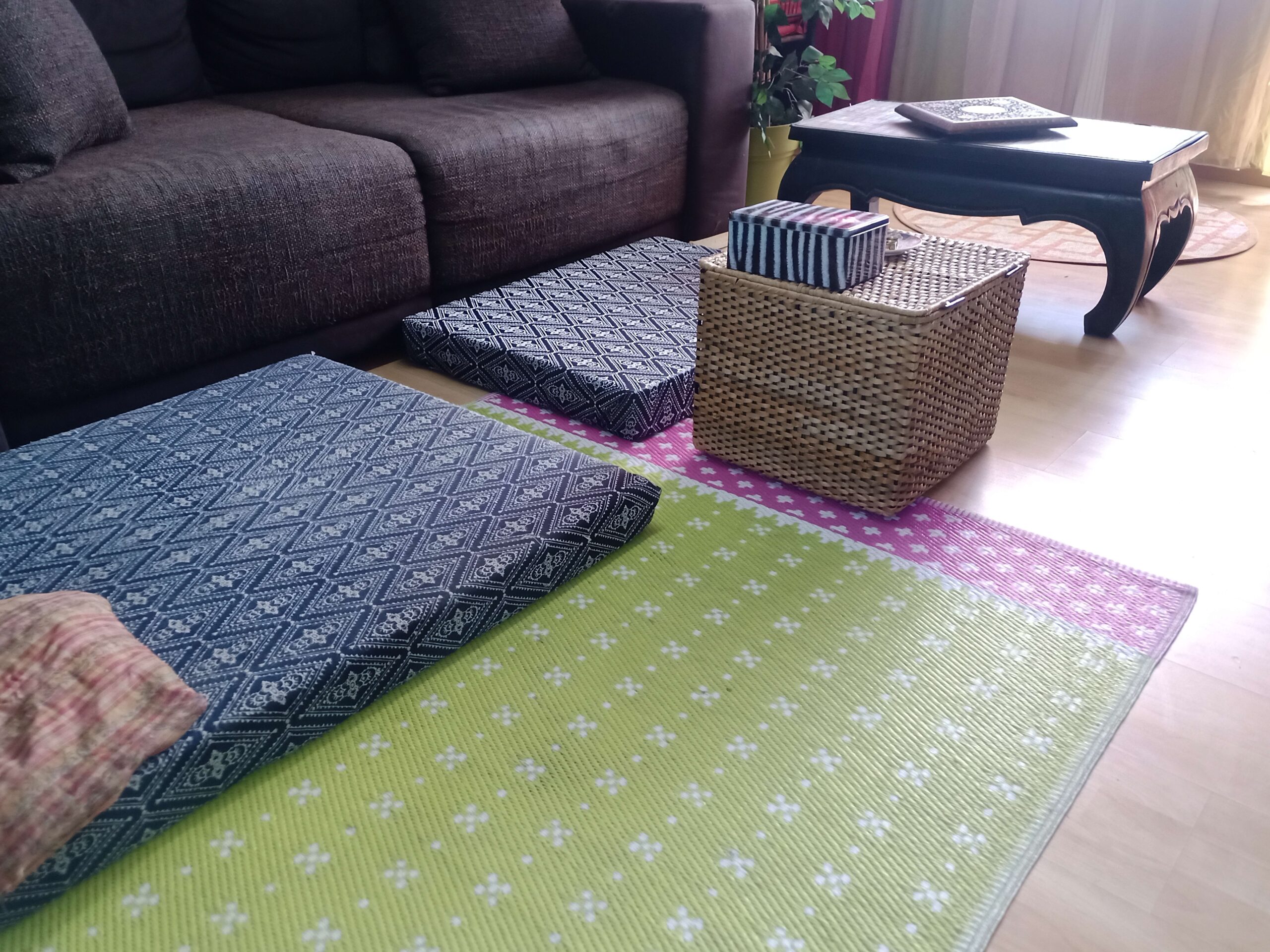 Boho-Wohnzimmer mit butem Teppich, Opium-Tisch und zwei großen Haustierbetten