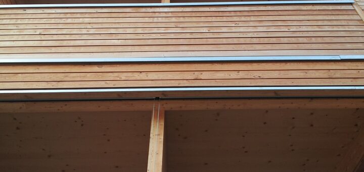 Moderne Holzfassade an Wohnhaus mit mehreren Stockwerken