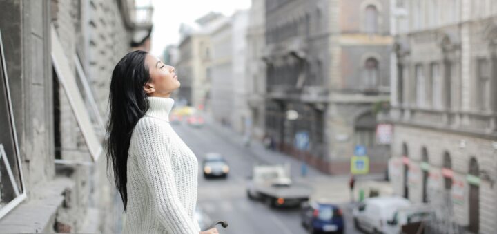 Frau in Großstadt auf dem Balkon